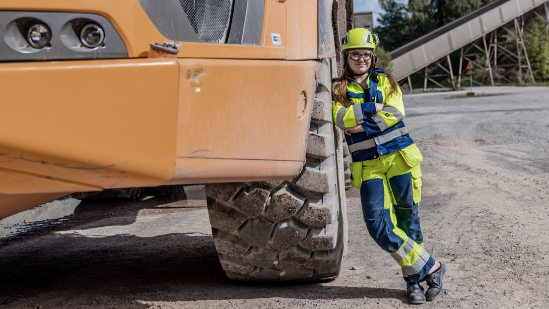 En person står lutad mot ett stort däck på en dumper.