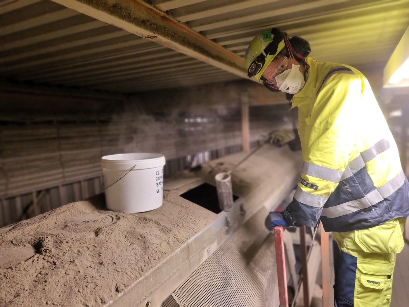 Person tar prov under produktion av cement i Slitefabriken