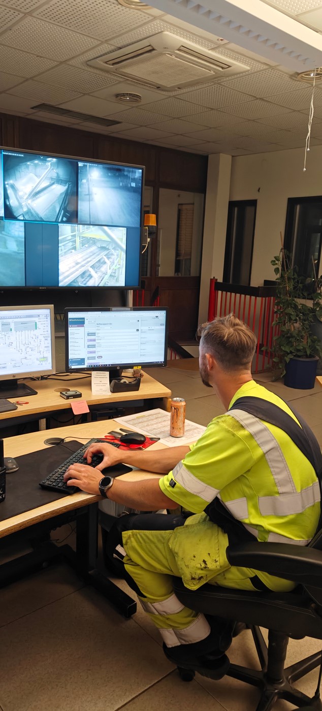 Person framför bildskärm i kontrollrum i cementfabriken i Slite