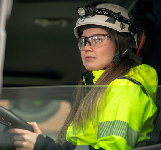 En kvinnlig lastbilschaufför i en förarhytt