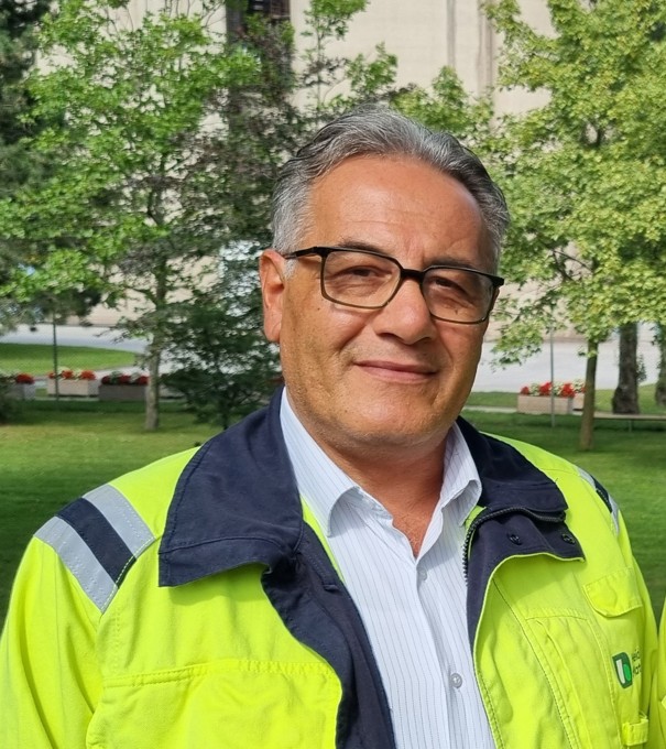 Anställd i gul reflexjacka på Heidelberg Materials företagsområde utomhus.