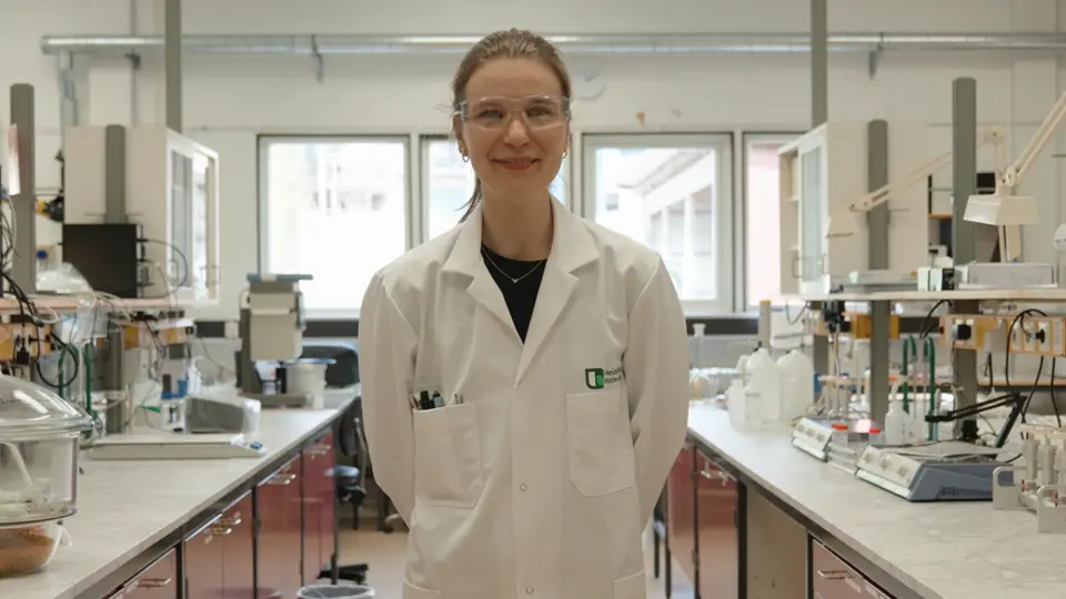 En person i vit labbrock står i ett laboratorium för byggmaterial.