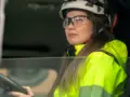 En kvinnlig lastbilschaufför i en förarhytt